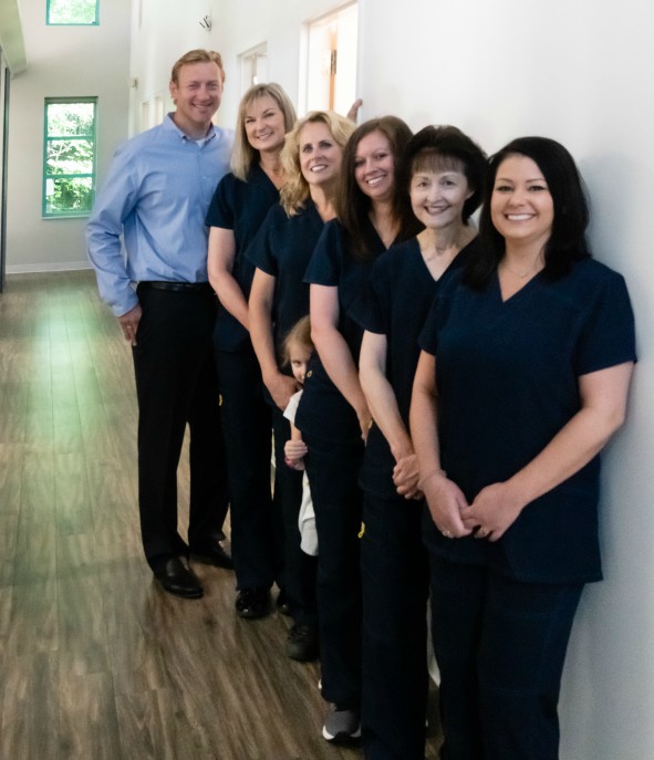 Staff of Durham DDS standing in a row inside the office.
